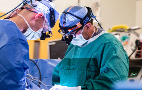 Two surgeons working to repair an aortic aneurysm.