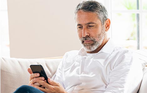 This older man takes the joint pain quiz on his phone to understand his knee pain