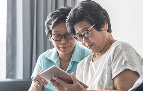 an older asian woman uses her tablet to talk to a UVA Health knee surgeon.