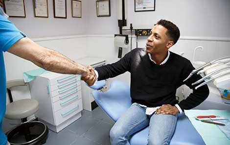 young man shakes hands with doctor before std testing